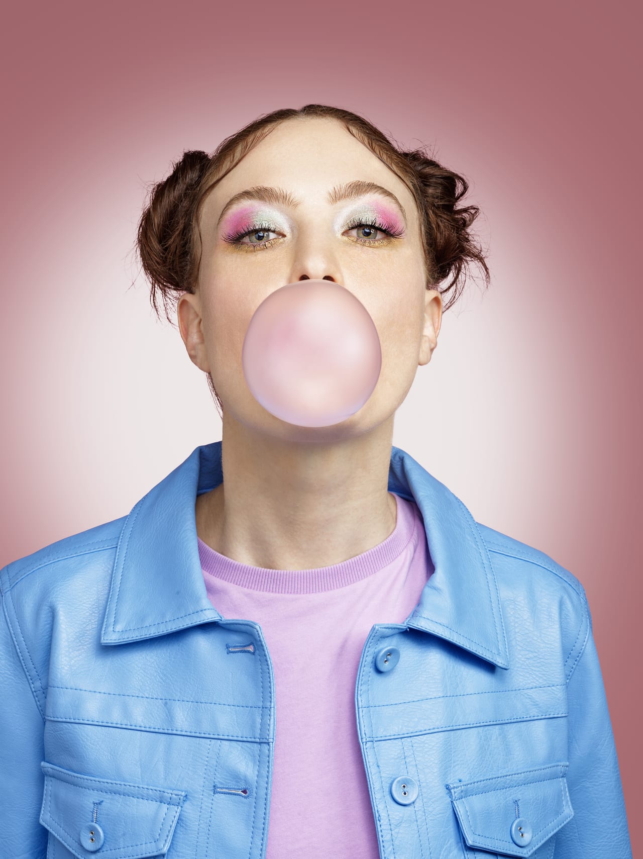 Ritratto di campagna su fondo rosa: ombretto rosa acceso e bolla di chewing gum.