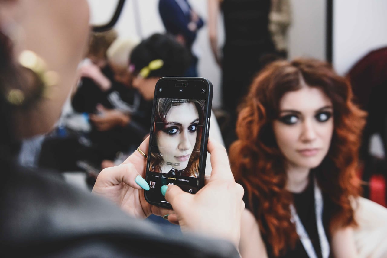 Dettaglio di un intervento di trucco durante un evento esterno.