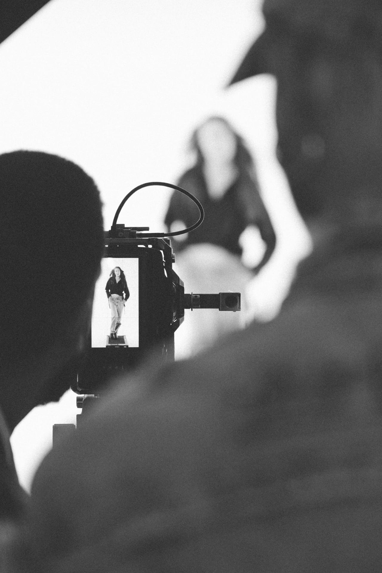Silhouette del fotografo davanti alla modella illuminata sul set.